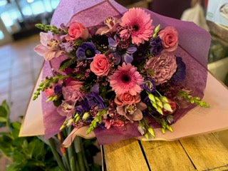 Pink roses, Gerber daisies, purple anemones, lisianthus and cymbidium orchid heads  garden bouquet – Jerome Florists NYC
