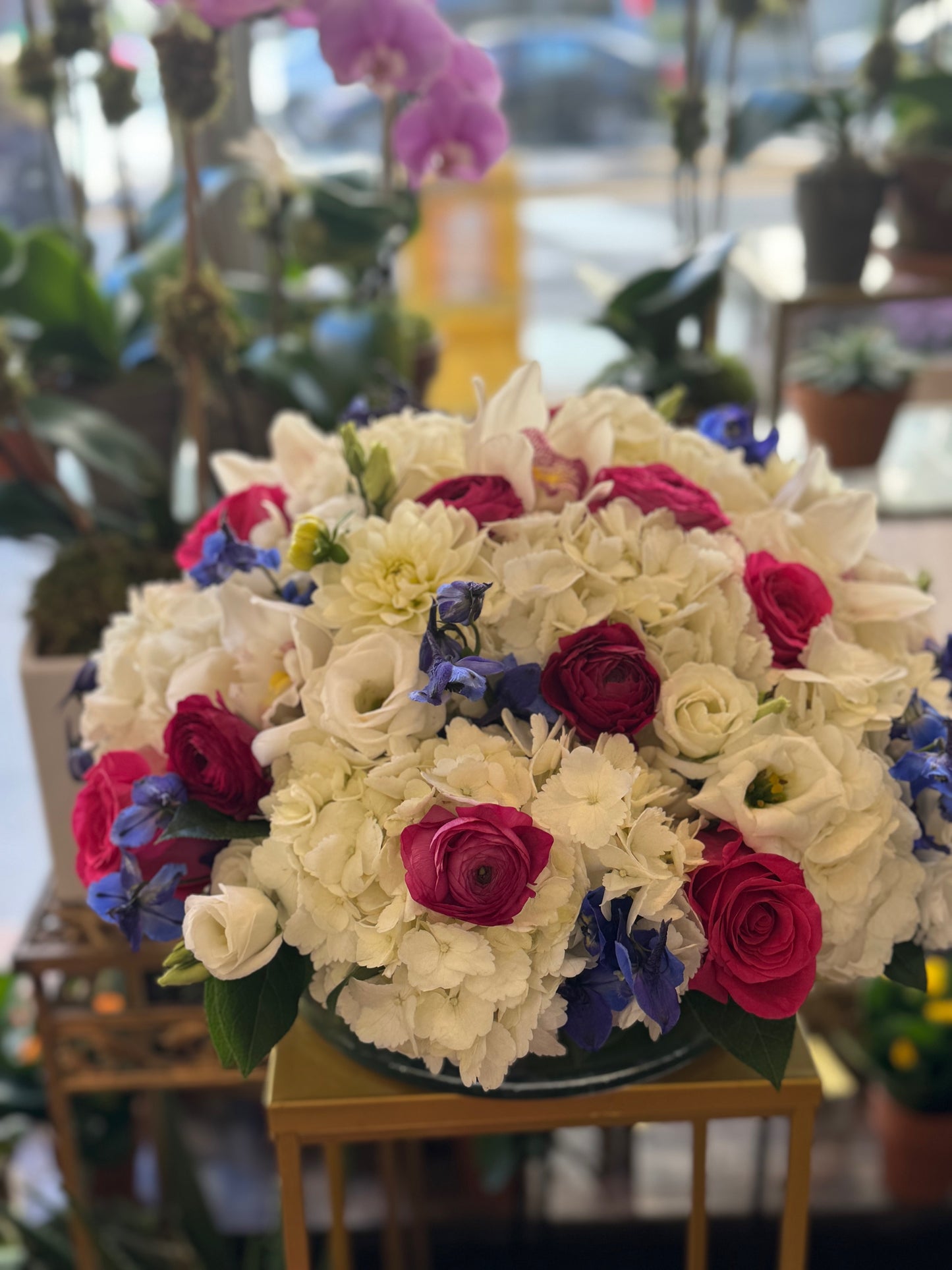 White hydrangea cymbidium orchid rose and ranunculus premium Round centerpiece – Jerome Florists NYC