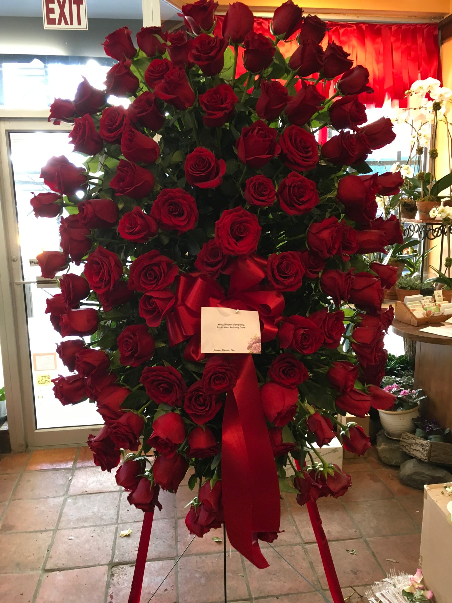 Tranquil roses sympathy spray with red roses on easel - Jerome Florists NYC