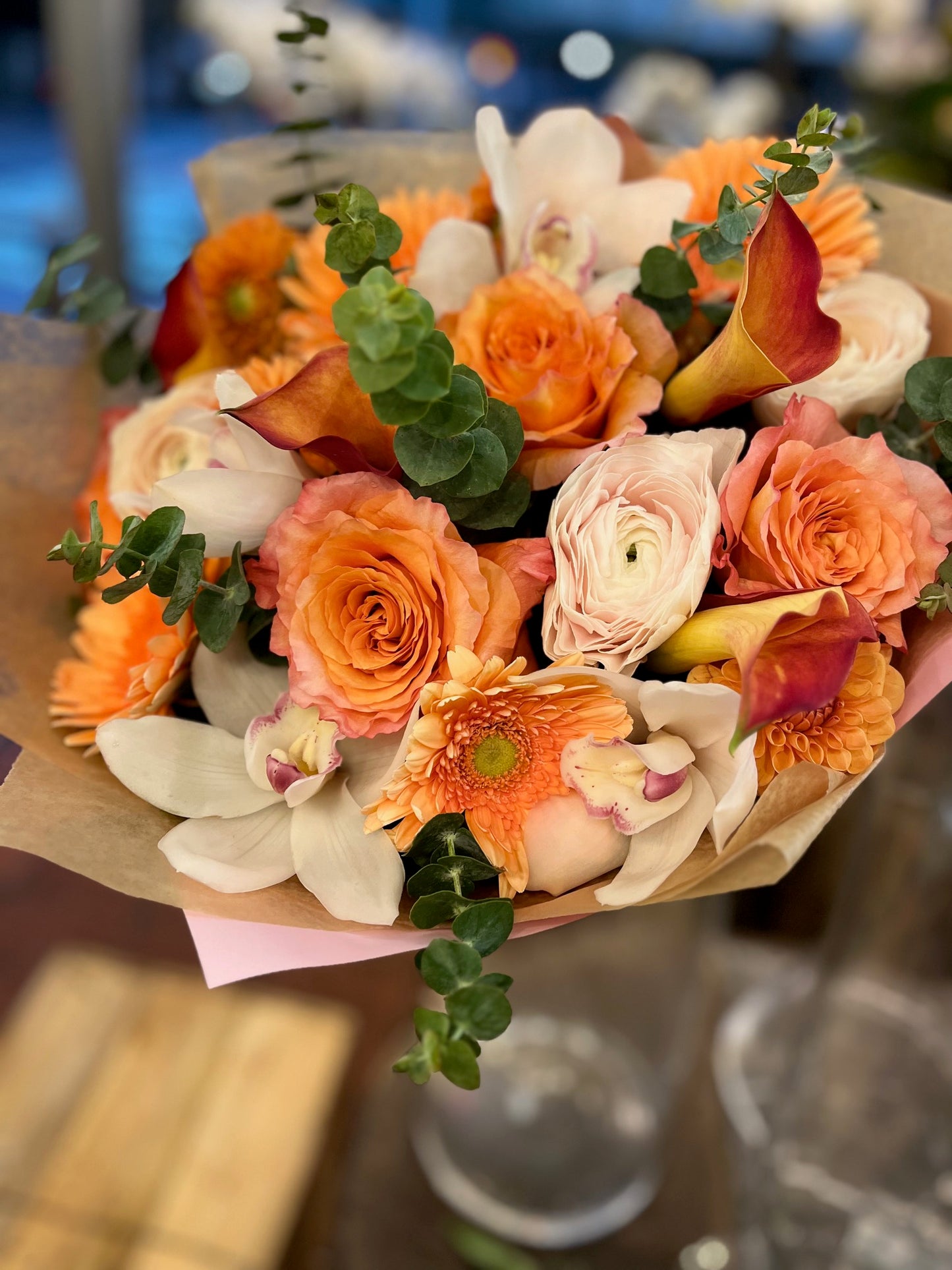 Orange pink roses, gerbera daisy, dahlias, cymbidium orchid heads, eucalyptus and ranunculus sunrise bouquet – Jerome Florists NYC