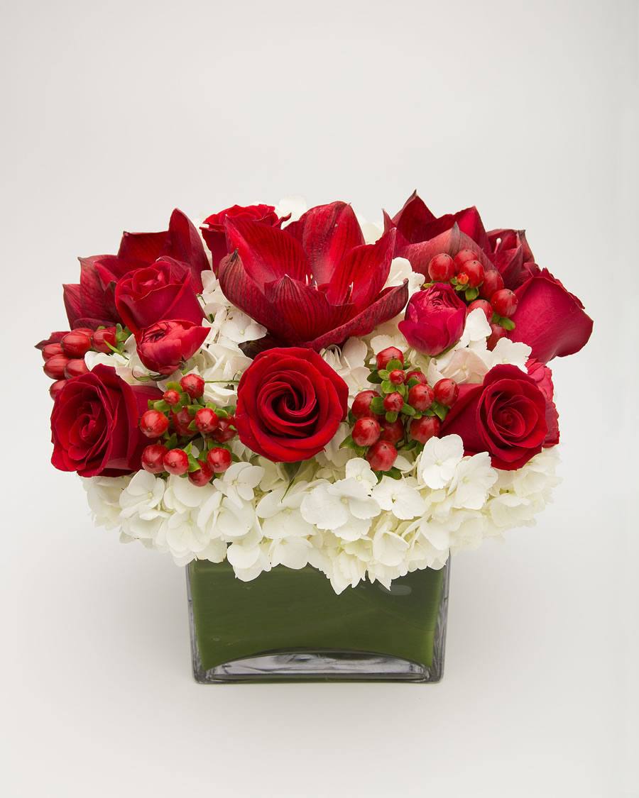 Floral arrangement with red roses, white hydrangeas, and red berries in a clear vase – Jerome Florists NYC