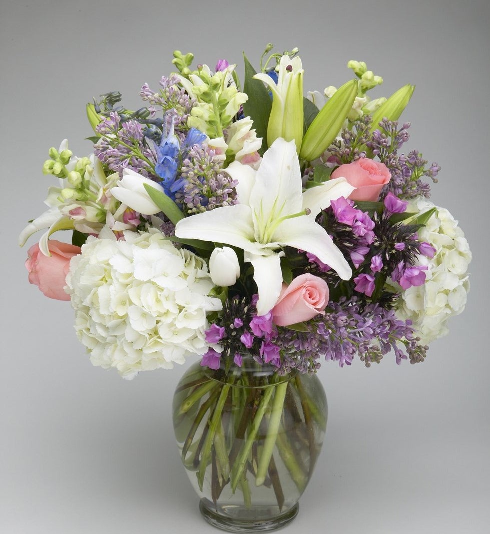 Pastel Cinderella flower arrangement with lilies, pink roses, hydrangeas, hyacinths, and snaps in a vase – Jerome Florists NYC